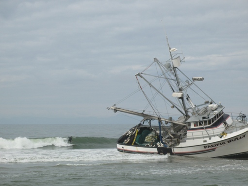 Boat gets beached in Huntington Beach - surfer in background